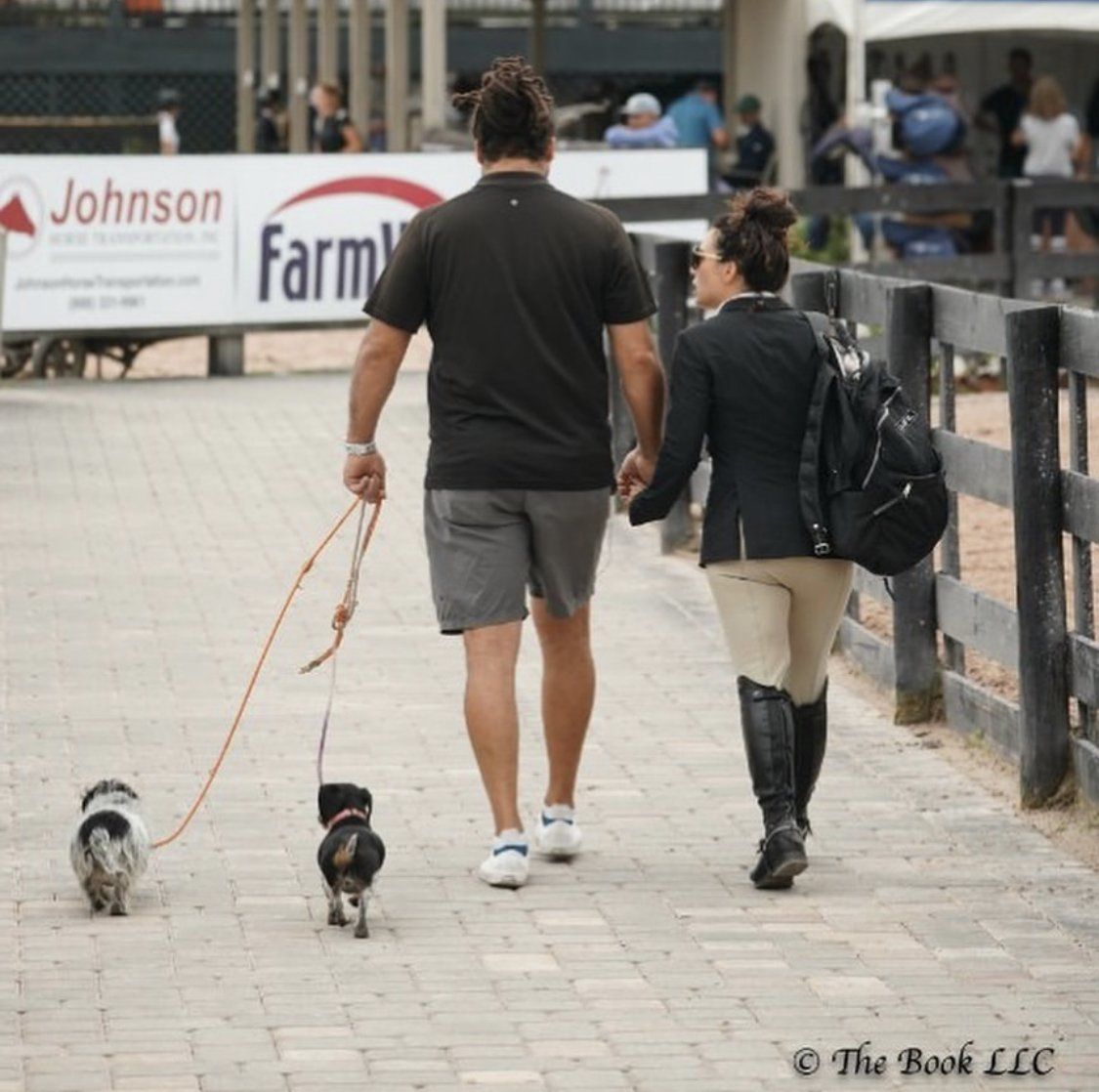 EquiFit Founder and President, Alexandra Cherubini, walking away from the camera with her husband and their two dogs.